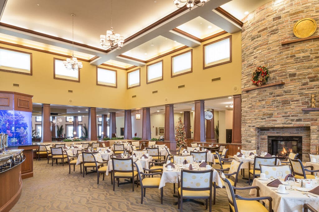 The grand restaurant area with dining tables, yellow cushioned chairs, and yellow walls.