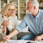 April 25 Events Page Image - Sumter Senior Living Elderly man and woman smiling and holding small dog